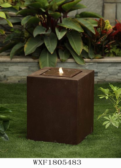 rust coloured cube with a water spout gently pouring water over the feature