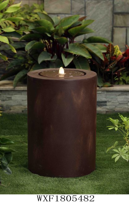 'Zen' rust coloured cylinder in a green garden